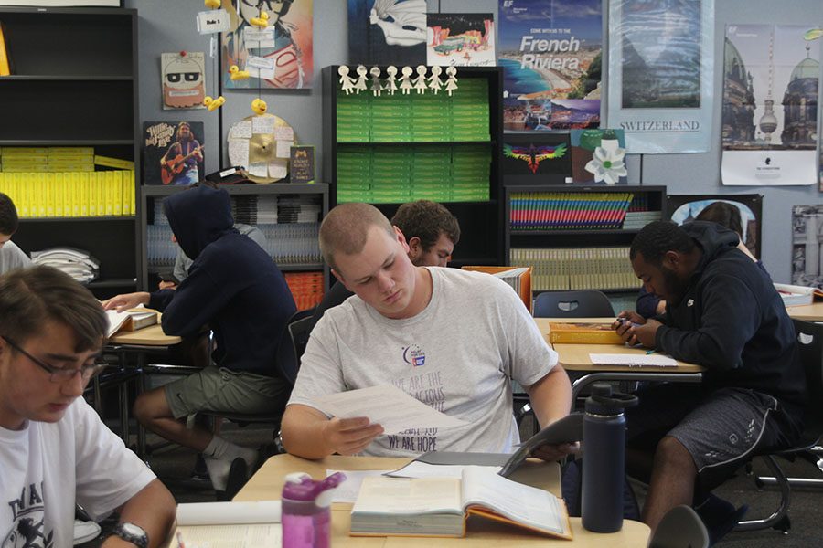 Reading over his assignment, senior Jake Smith listens to English teacher Kristen Crosbies instructions. 