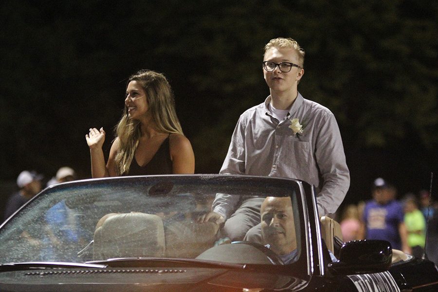 Riding down the track, seniors Lilli Milberger and Jack Mahoney wave to spectators.
