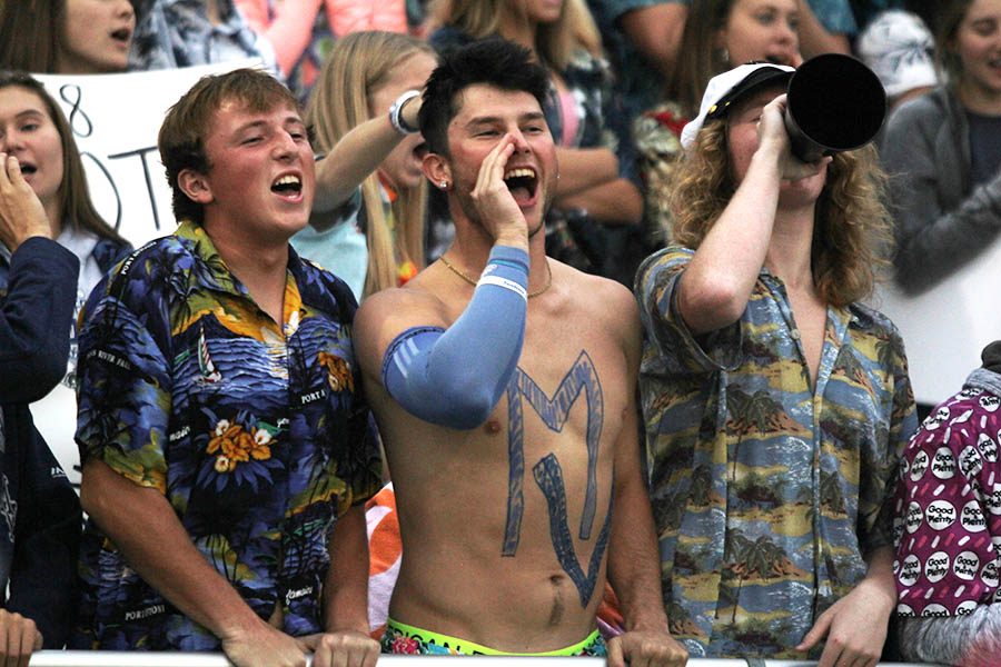 Waiting for a kickoff, seniors Aidan Veal, Quinton Hall and Killian OBrien join the rest of the student section in yelling.