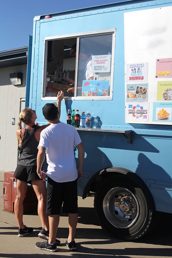 Paying for her food, a member of the community supports the Sprague family at the kickball event.