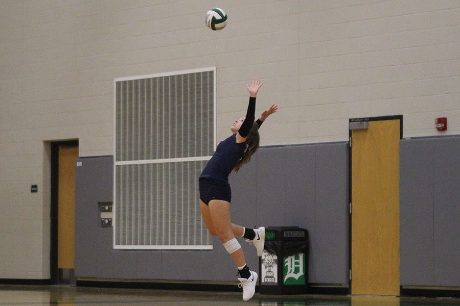 While in the air, sophomore Anna Judd serves the ball, at DeSoto High School on Thursday Sept. 20. We battled and fought our hardest to make it a close game, even though we didnt win, we left it all out on the court, Judd said.