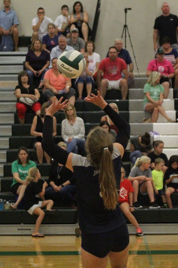 Raising two hands above her head, sophomore Anna Judd sets up a ball for her teammate.
