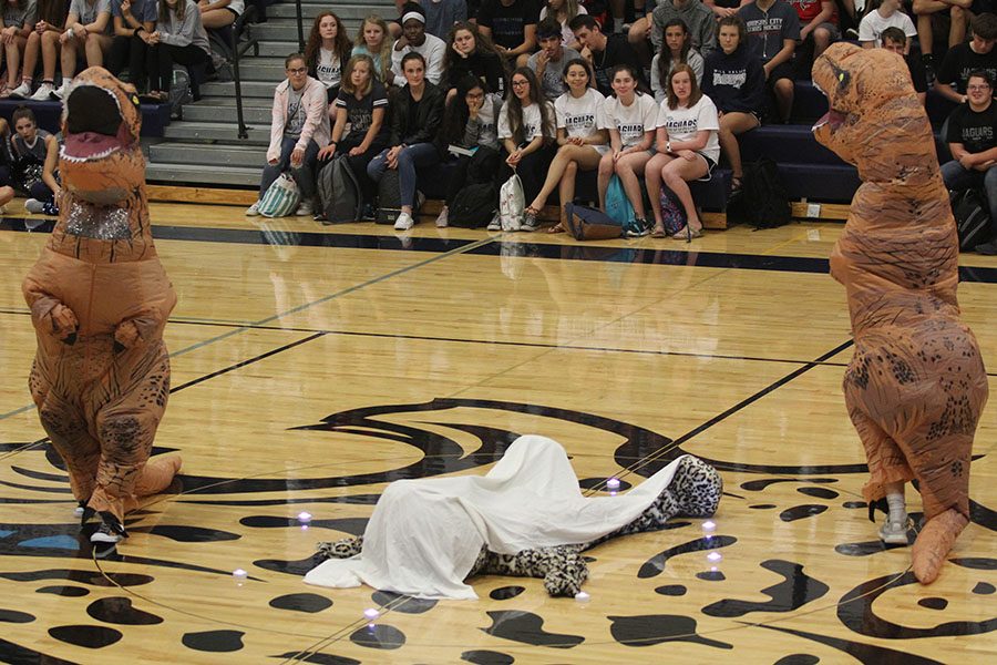 Circling around JJ the Jaguar, two dinosaurs resurrect the school spirit.