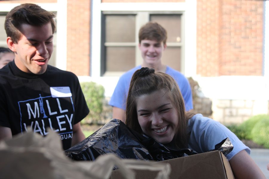 Picking up a large box full of school supplies, senior Annie Myers drops off supplies donated to a Youth for Refugees school supplies drive at Kansas City International Academy. When we went to drop off the donations, I was excited to see where and to who they were going to, Myers said. Its one thing to bring in pencils and paper to school, but actually seeing how its directly impacting the kids is an entirely different experience.