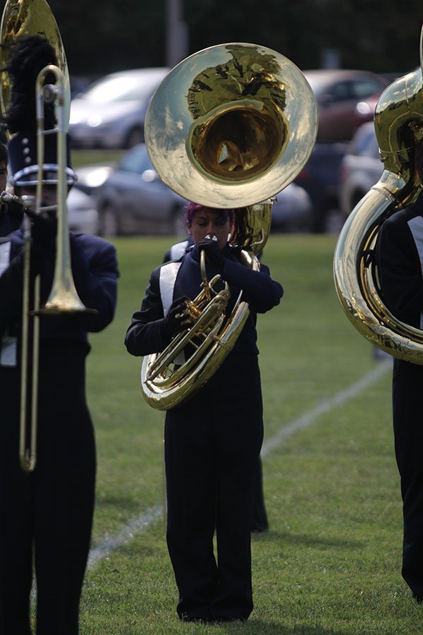 Marching in line with her bandmates, freshman sousaphone player Olivia Franco warms up before the Emporia State Marching Festival on Wednesday, Oct. 3.
