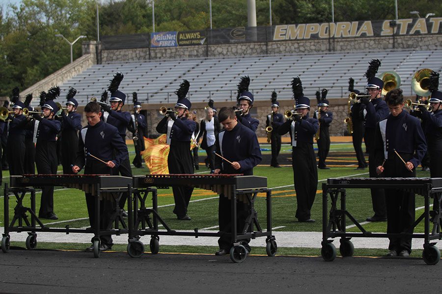 Striking the first few notes on the bells, the newly established percussion pit, made of junior Cahill Eckardt, sophomore Aiden Hazlett and junior Logan Arnold, perform at the Emporia State Marching Festival on Wednesday, Oct. 3. 