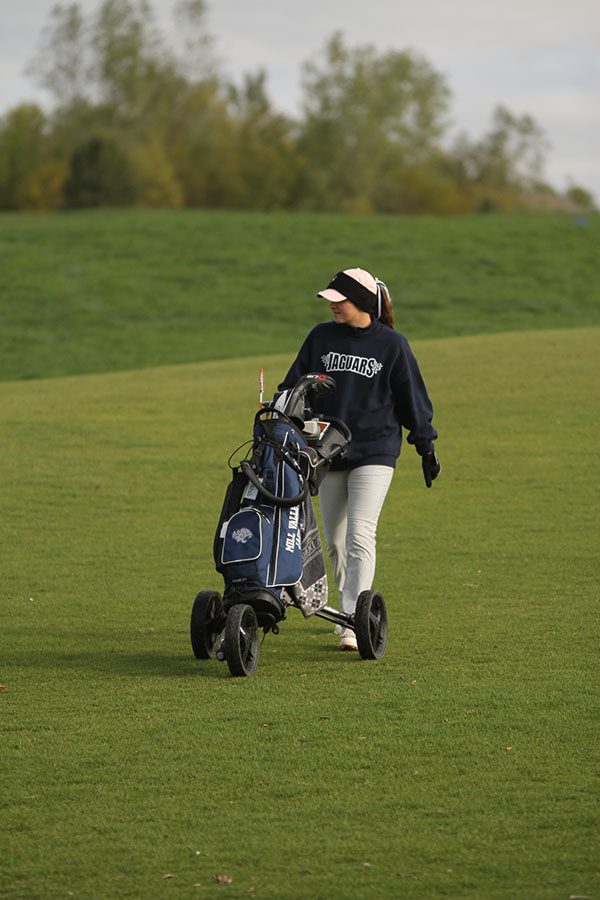 Walking down the fairway, senior Sarah Lawson chats with the other two golfers in her tournament group.