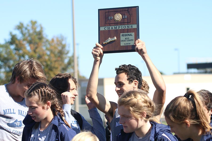 Holding the boys 6A first place regional plaque up in the air, senior Matt Turner smiles at junior Darius Hightower at Johnson County Community College on Saturday, Oct. 20. 