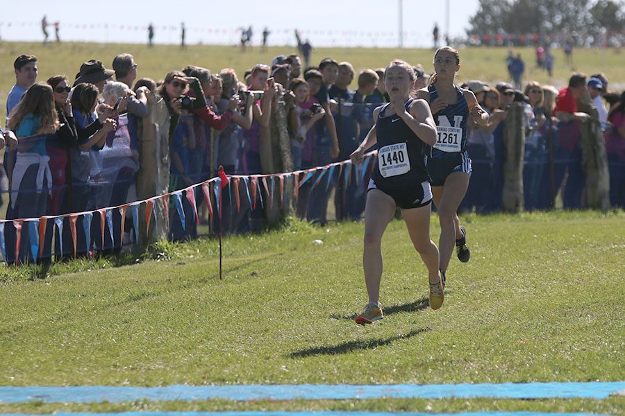 In her final state appearance, senior Delaney Kemp secures her fourth place finish by keeping just ahead of another runner.