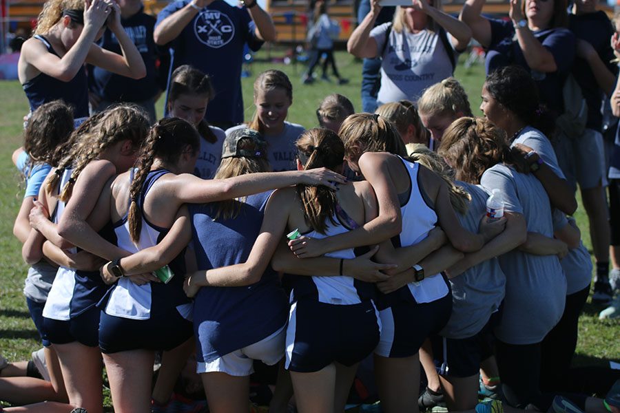 Circling together, the girls bow their heads for a word of prayer after hearing the news of their state championship.