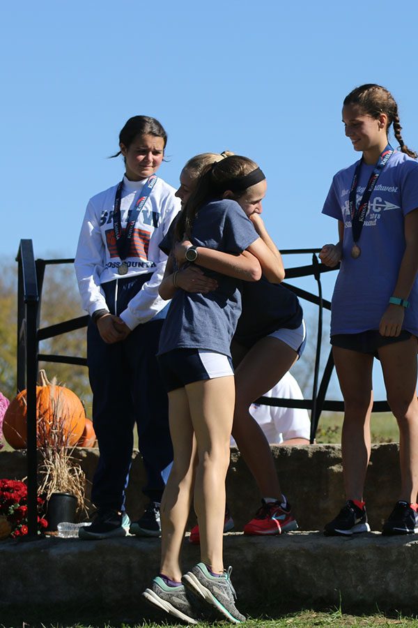  In a hug exchange, sophomore Josie Taylor and junior Morgan Koca congratulate each other on their placement.