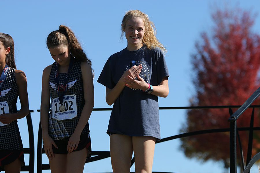 Recently receiving her medal, sophomore Molly Ricker smiles at her family.