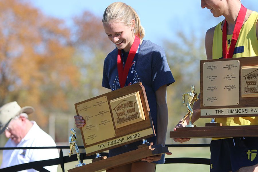 Freshman Katie Schwartzkopf receives the traveling Timmons award after earning the top girls cross country time in the state of Kansas.