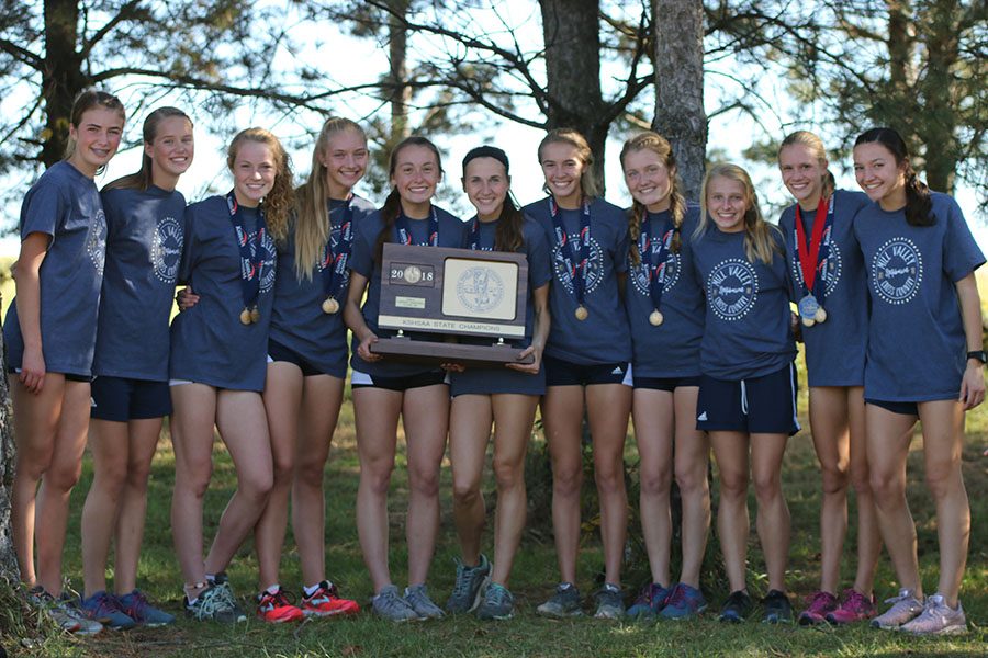 After placing first at state for the first time in school history, the girls cross country team holds up their championship trophy at Rim Rock Farm on Saturday, Oct. 27. “Sometimes you just have to expect for something to happen in order to achieve it,” senior Delaney Kemp said about their results.