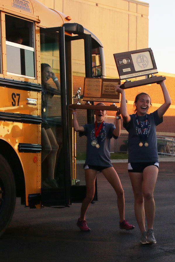 With the trophy held high, the team exits the bus after their police escort back to the school.