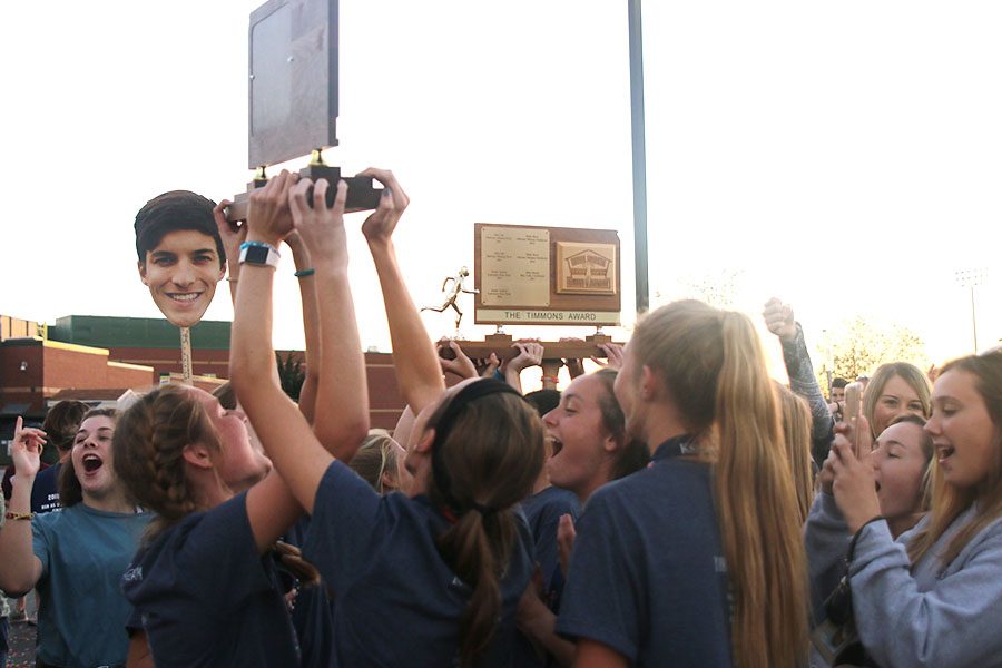 Along with gathered family, friends and community members, the girls cross country team celebrates their win together.