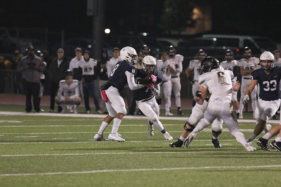Handing off the ball, senior Jordan Preston gives it to senior Cameron Young to run upfield. With a final score of 18-7, Mill Valley won on Friday, Oct. 12. [Everyone] worked hard especially my o-line which allowed me to open some holes and score a few touchdowns which gave us the momentum to play even harder, Young said.