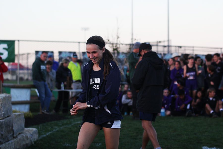 Taking her place at the podium, junior Morgan Koca accepts her medal with a smile.