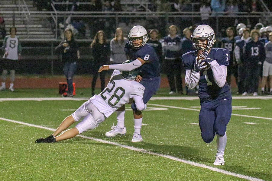 After being thrown the ball, senior Cameron Young runs the ball downfield against Blue Valley Southwest on Friday, Oct. 19. “It’s the best feeling there is.” said Young “There is nothing like playing on Friday night with your brothers by your side.”