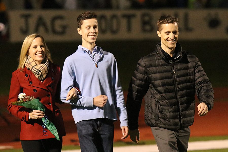 At senior night on Friday, Oct. 19, fall sport seniors were recognized. As he walks with his parents, senior Ryan Williams is recognized for his participation in cross country. 