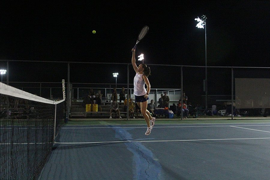 Leaping into the air,  senior Anika Roy attempts to smash the ball past her opponents to win the point.