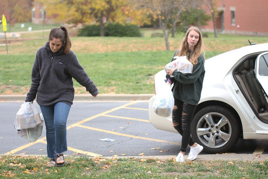 Unloading their car, senior student body president Hannah Barnes and senior student body treasurer Kate Backes bring their donations to the school for pick-up.