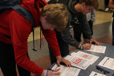 Seniors Hunter Harris and Steven Colling stand side by side as they register to vote.