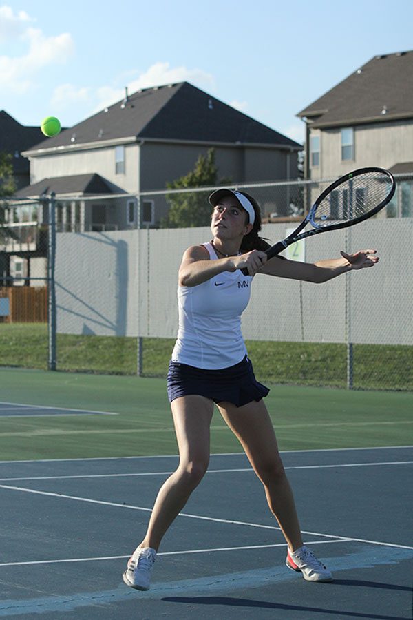 Attempting to backhand the ball over the net, sophomore Sophie Lecuru lines up the shot.