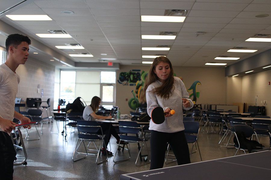 As she returns the ball, sophomore Addison Stover plays in a doubles game with senior Eric Schanker. 