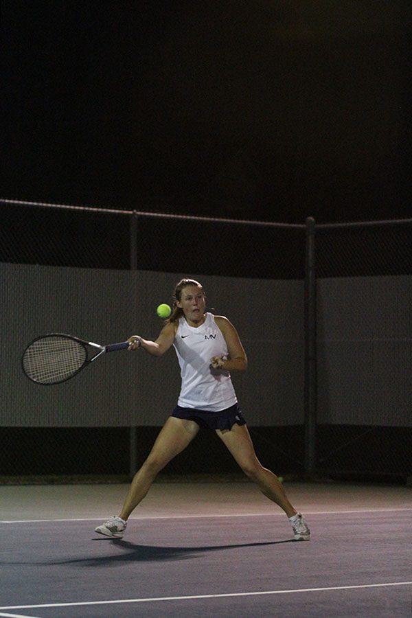 Volleying back and forth with her opponents, senior Anika Roy hits the ball.