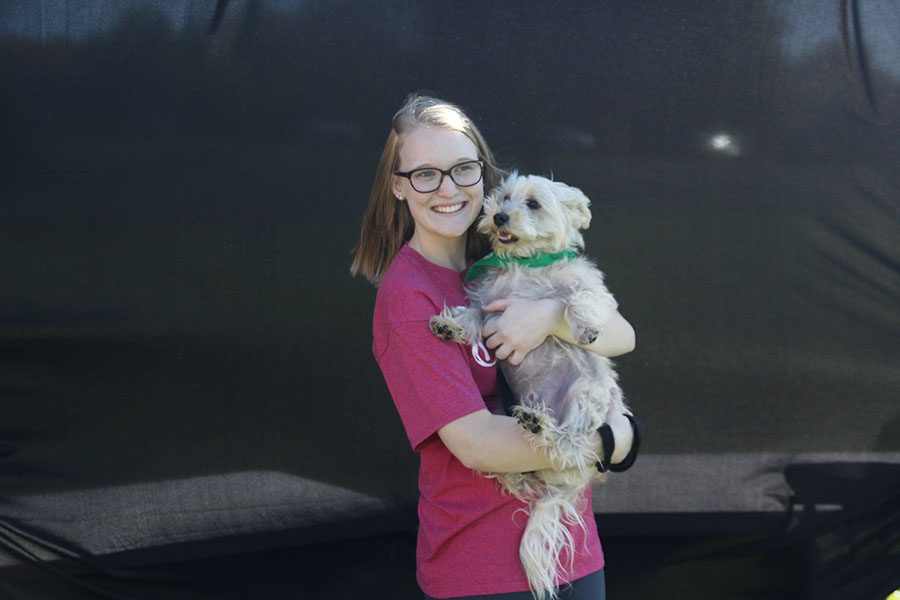 Posing with her dog for the photo booth, junior co-chairman Abbie Morgan takes a picture with her dog.