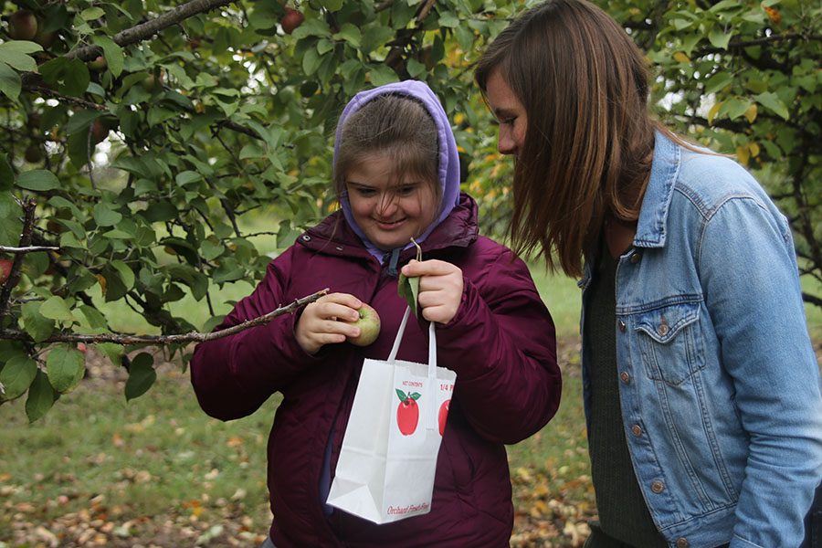 After picking an apple at Cider Hill Family Orchard on Thursday, Oct. 11, junior Maria McElwee and senior Madi Reishus admire their find.