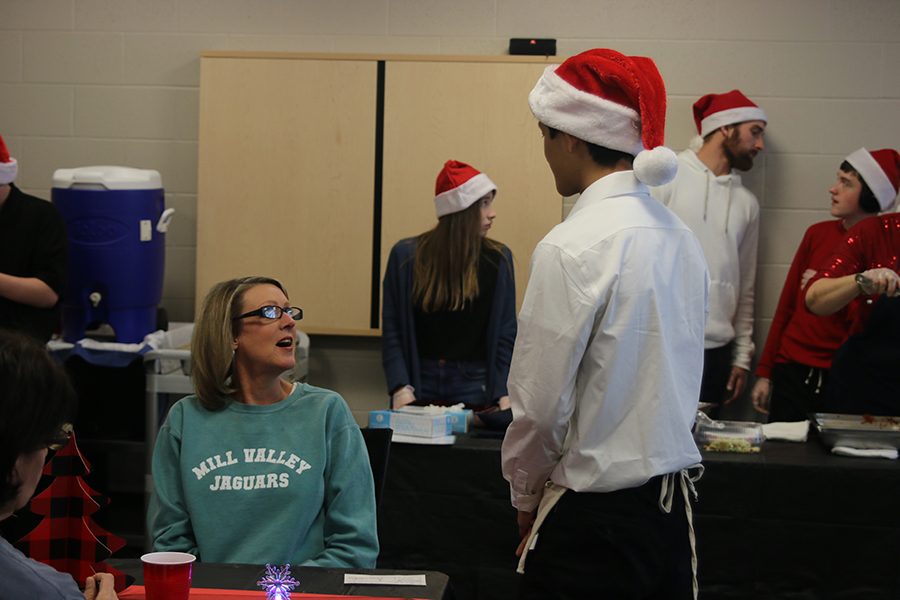 As part of his job rotation, junior Tyler Draper takes secretary Amy Sanders’ drink order.