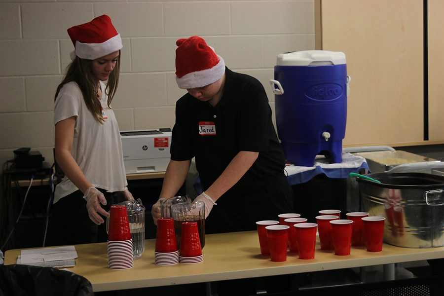 With help from junior Rylee Fouts, junior Jared Brehaney sets out cups to fill with beverages requested by faculty.