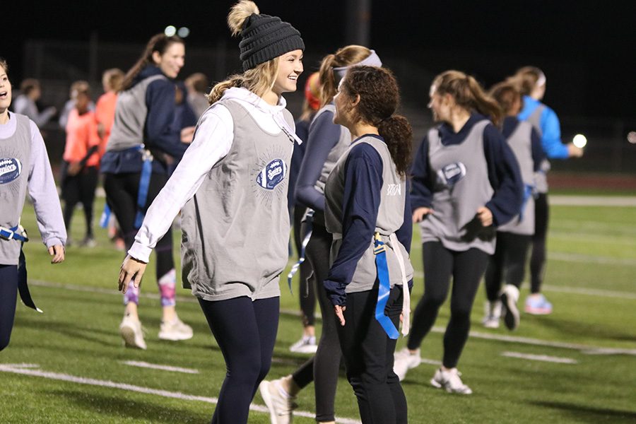 Walking off the field, senior Haley Puccio smiles and shakes senior Presley Bartons hands after an interception was made during the Powderpuff game on Monday, Nov. 5. 