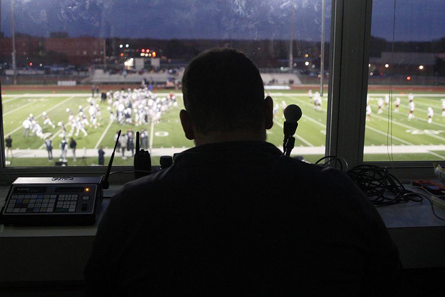 Before the game starts, announcer, Nick Peirce recognizes both football teams as they run out onto the field on Friday, Nov. 5. “The most important part of my job is watching the game closely,” Pierce said. “While teams are stretching, I try to get skills players names I would likely be saying the most.” 