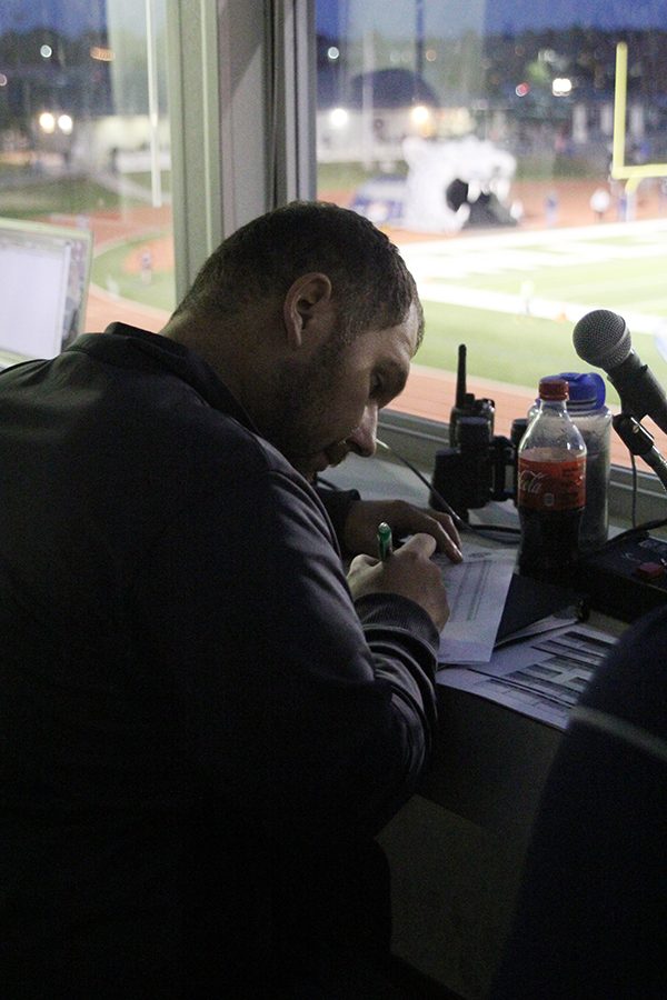 Focusing on his clipboard, announcer Nick Peirce goes over last minute details before the game starts.