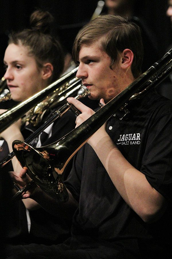In the middle of a rest throughout the piece of music, junior trombone player Jacob Howe takes a moment to look up at the conductor to get the cue when to play again.