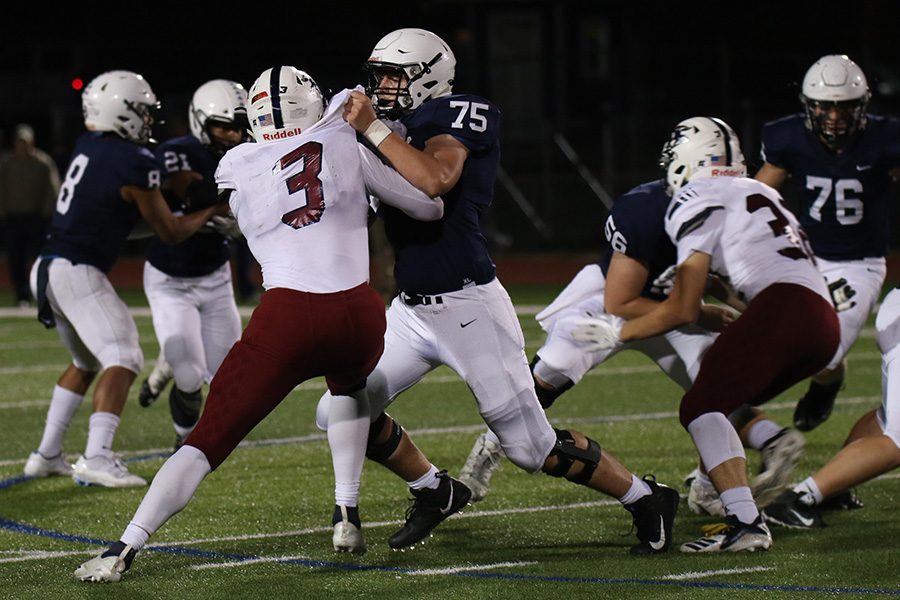 Face to face, sophomore offensive lineman Sam Hecht blocks an opponent from advancing.