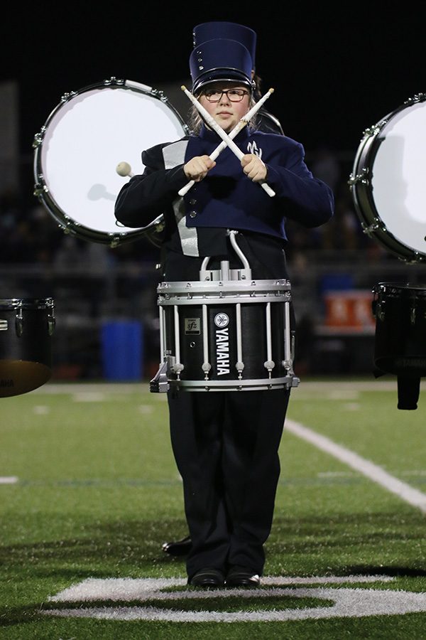 In the middle of the set, junior Abby Lee makes an X with her drumsticks as a visual element to the band’s performance.