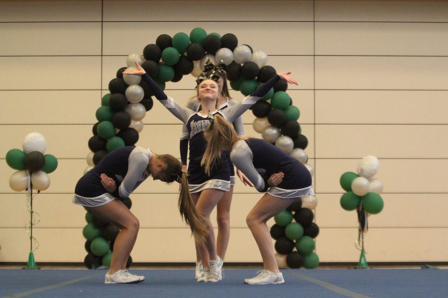 Striking a pose, junior Trinity Ouellette and her stunt group begin their routine.