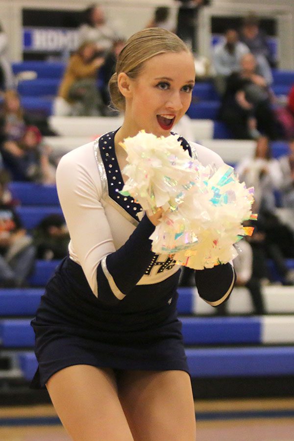 Rubbing her poms together, freshman Hadley Skinner performs in the pom routine at the Kansas City Classic on Saturday, Dec. 8.