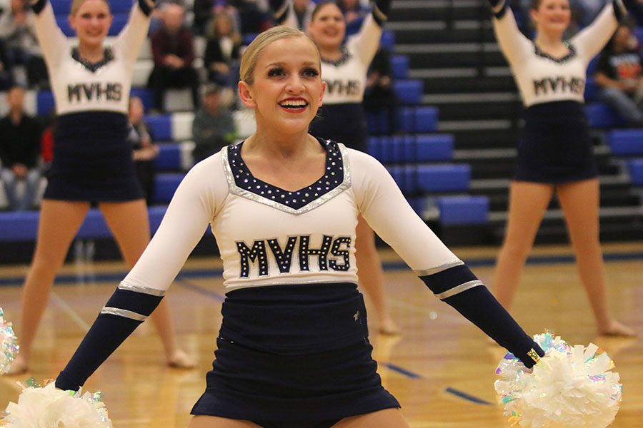 With her arms in a low-v, senior Bella Line smiles at the conclusion of the pom routine at the Kansas City Classic on Saturday, Dec. 8.