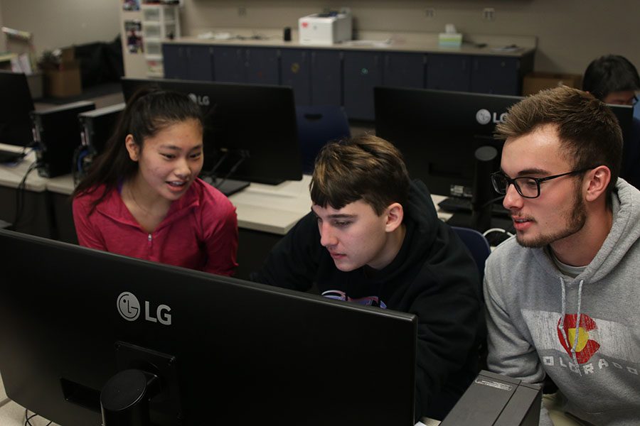 While working on their year-long engineering project, seniors Libby Mullican, Johannes Seberger and Kaden Beck discuss what materials they should use. 