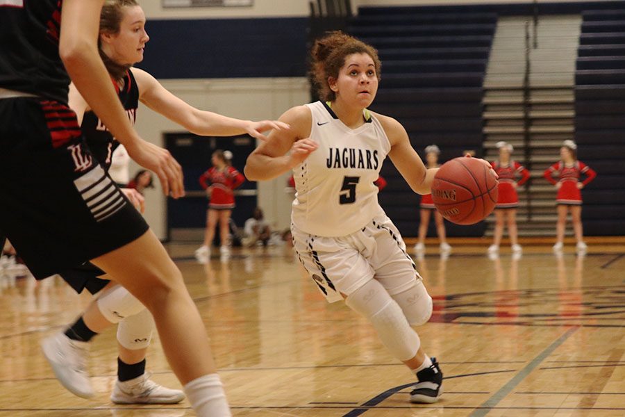 Dribbling down the court on offense, senior Presley Barton avoids Lansing defenders as she approaches the basket on Tuesday, Jan. 15.