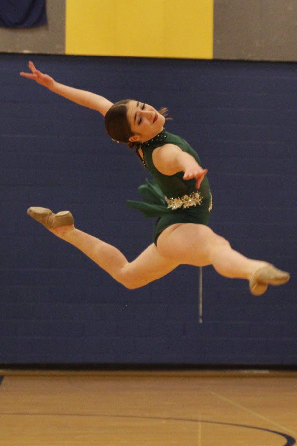 Leaping into the air during her solo, freshman Anna Brazil matches her facial expression to the music. 