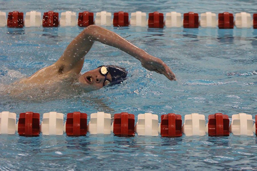Coming up for air, freshman Grant Nelson competes in the 500 yard freestyle relay.