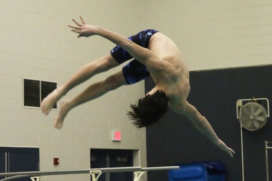 In his high school swimming debut, sophomore Mason Davis flips into his fourth dive.