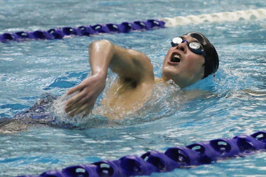 Just past the flags, freshman Grant Nelson comes up for air on the second lap of his 200-yard freestyle race.