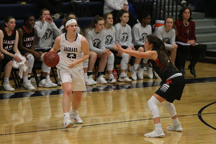 Looking past her opponent, senior Claire Kaifes dribbles the ball before passing to her teammate.